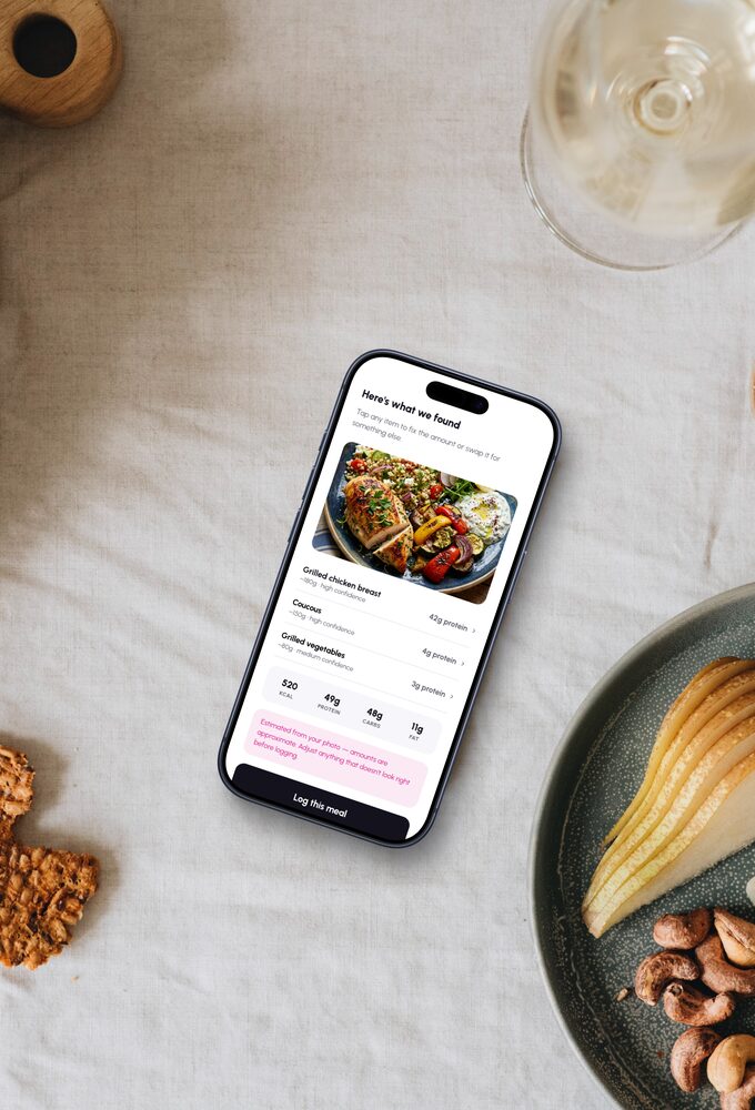 An evening table of cheese, pears and grapes, the app’s meal log open on a phone among them